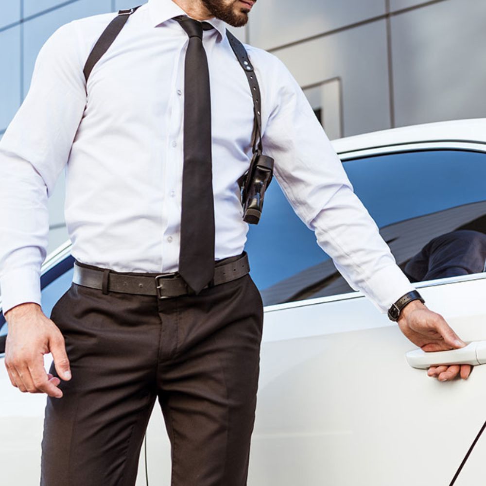 Escolta ejecutivo armado realizando protección de perímetro para cliente VIP